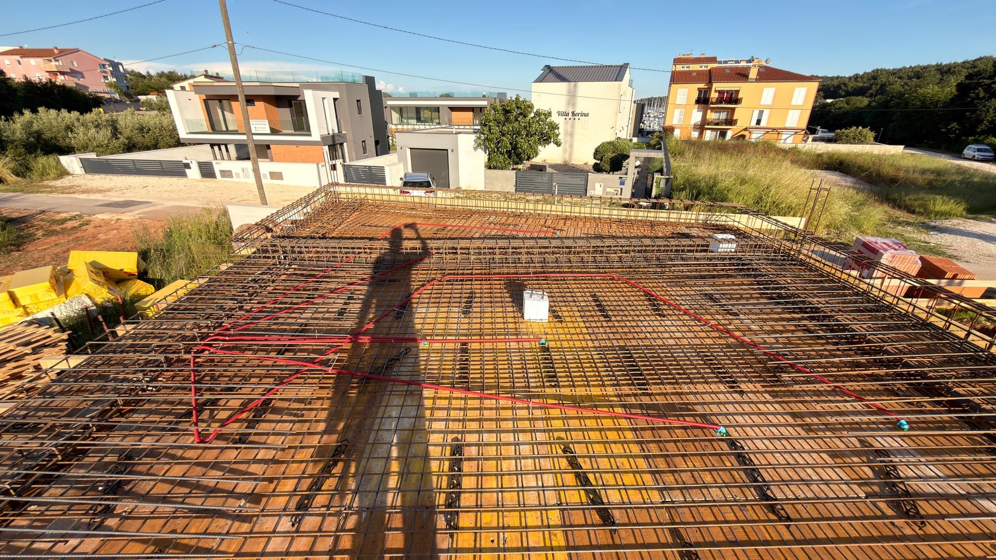 Conduit runs laid into the reinforcement of a floor slab before the concrete pour.