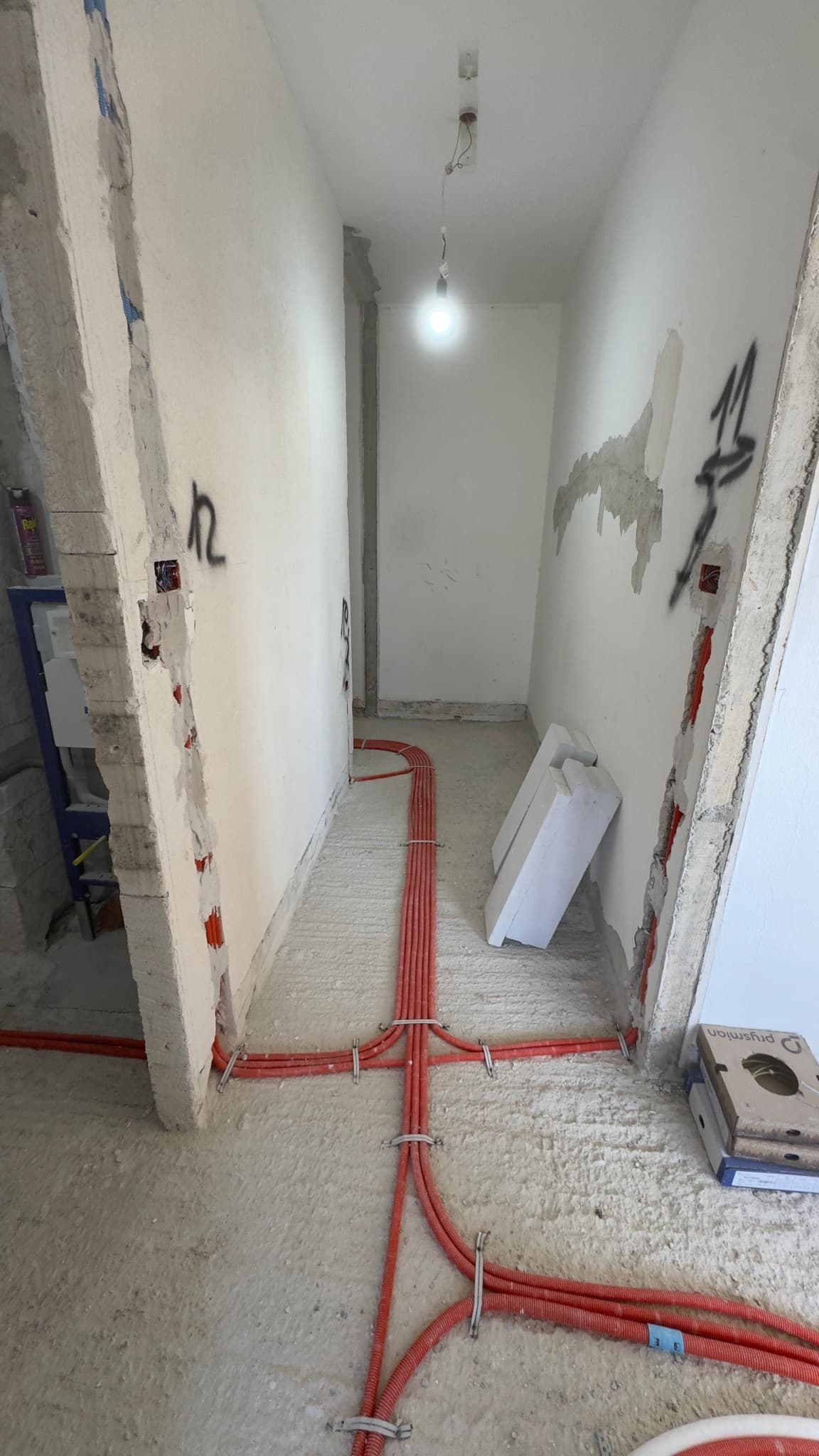 Conduit runs laid along a hallway floor during first-fix work.