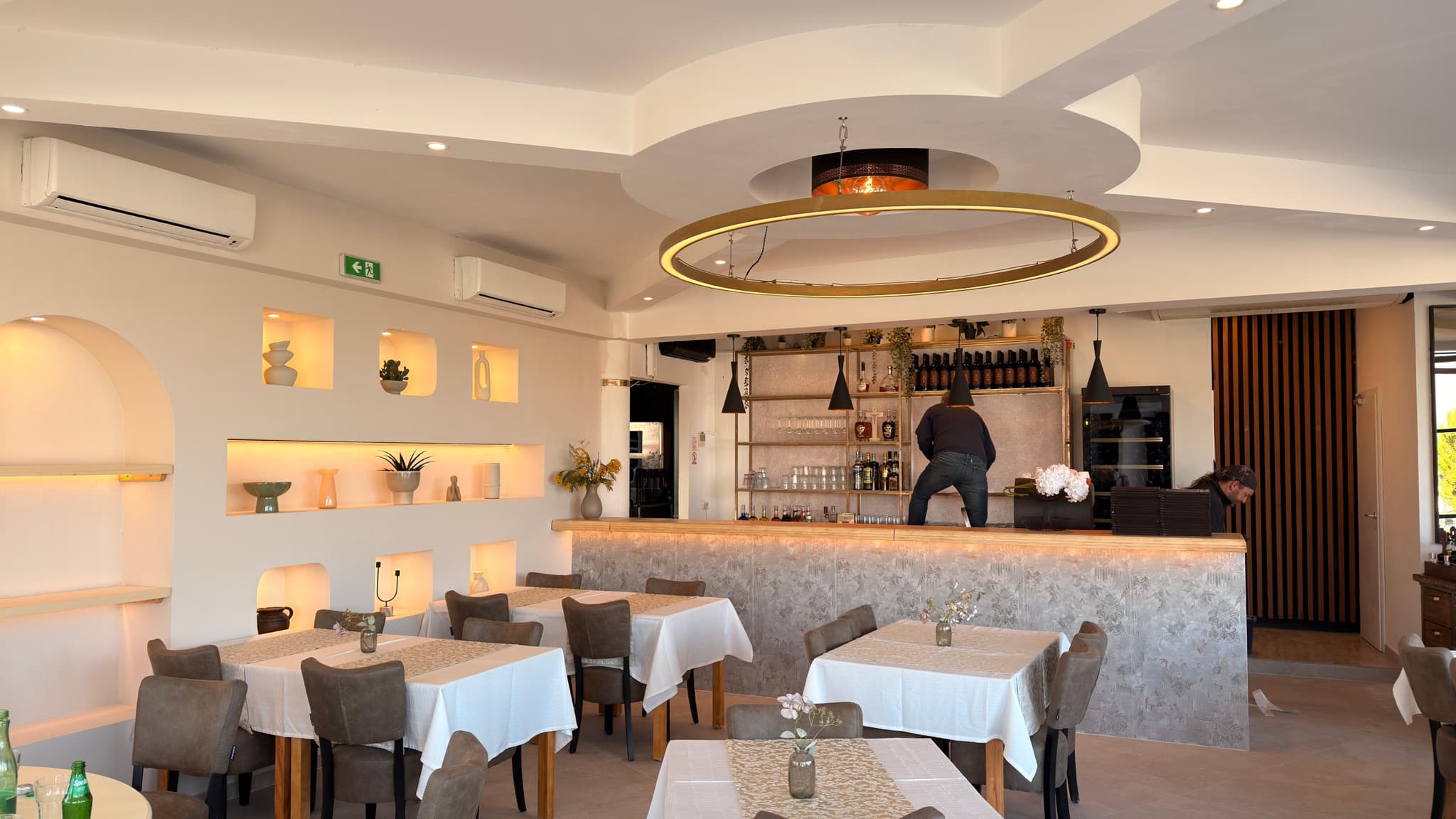 Lit bar and seating area in a finished restaurant.