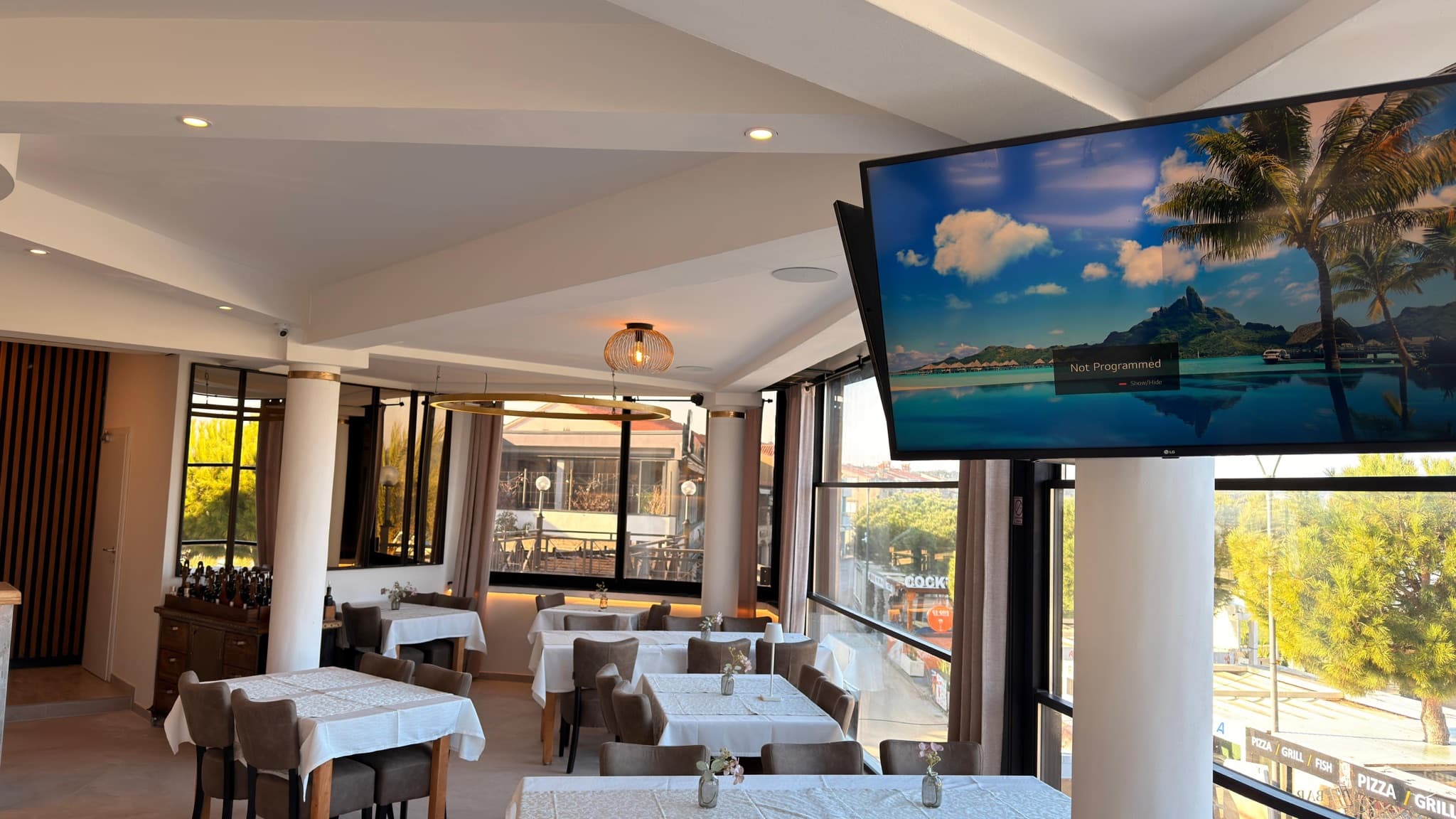 Wall-mounted television and recessed lighting in a restaurant space.