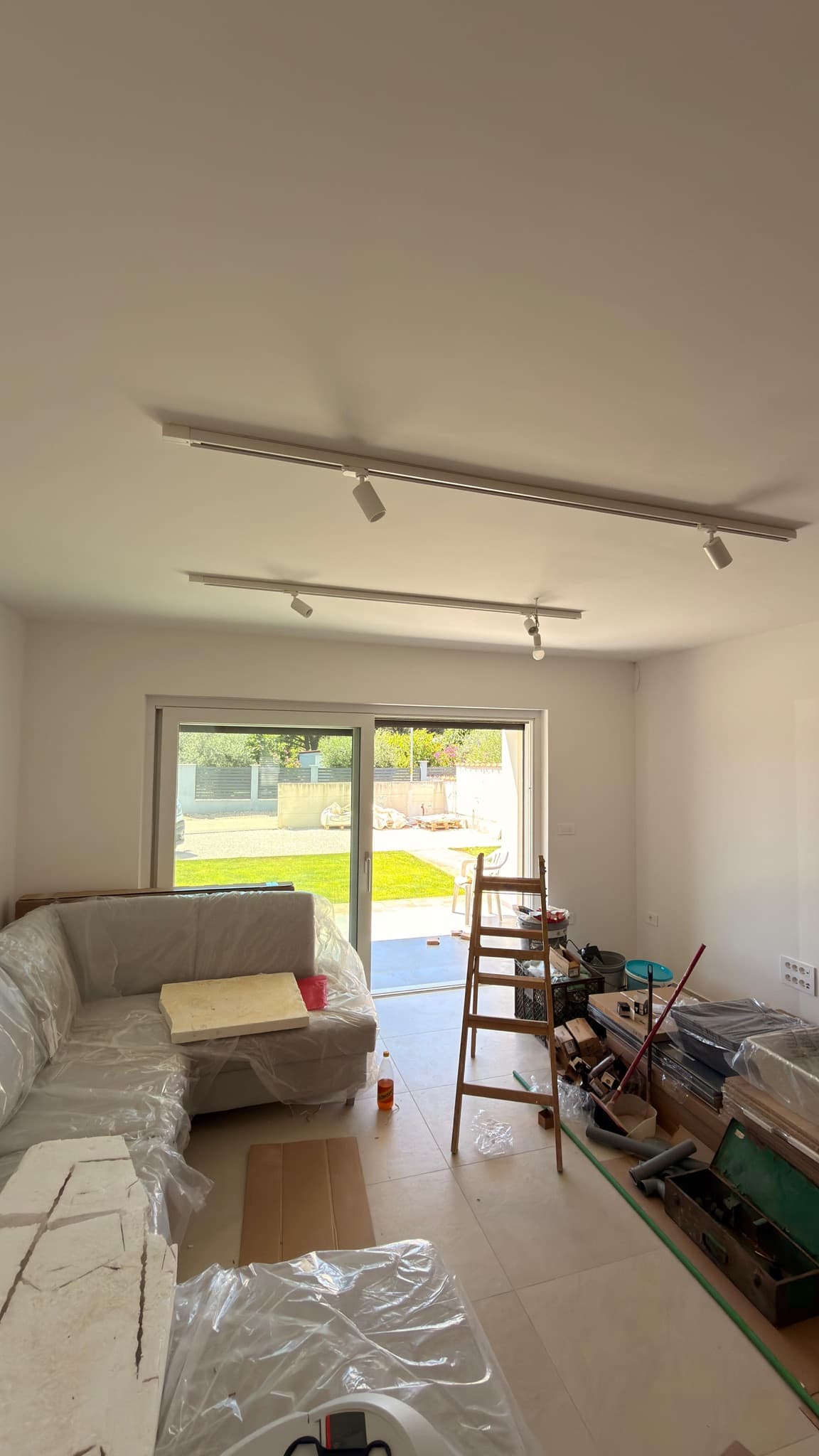 Track lighting in a living room with sliding doors onto the garden.