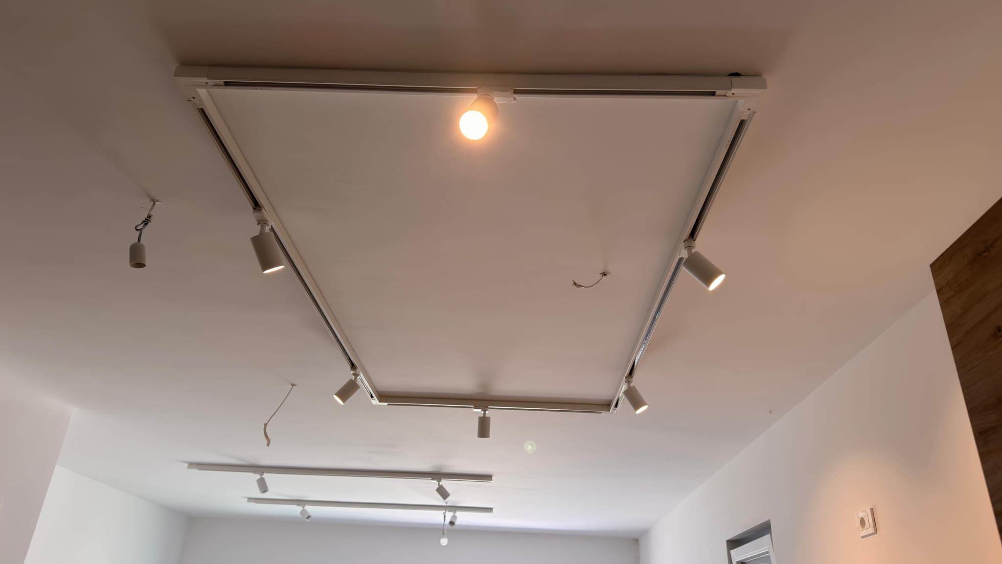 Ceiling track lighting with adjustable spots during installation.