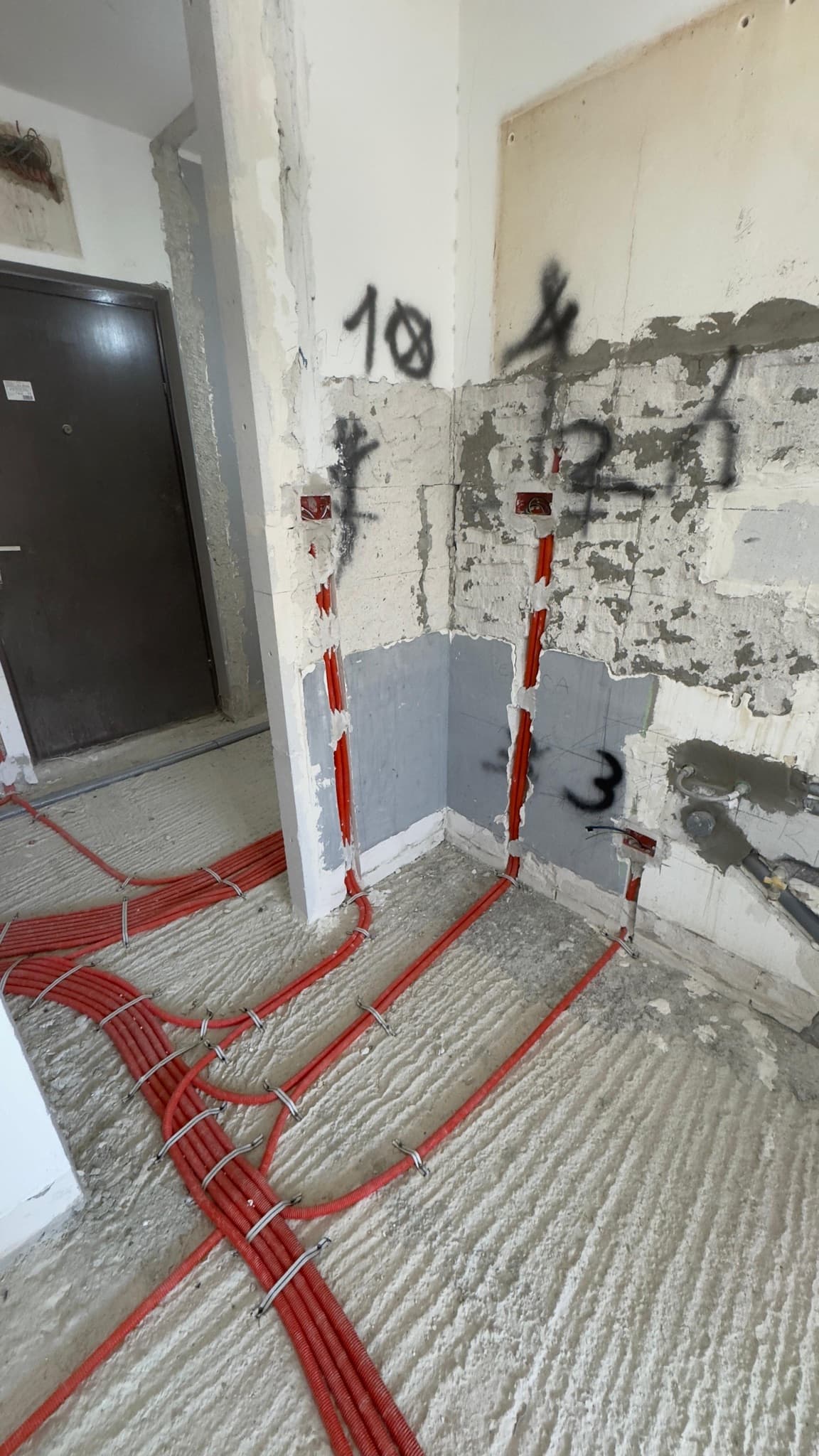 Chased walls with marked socket positions during an apartment renovation.