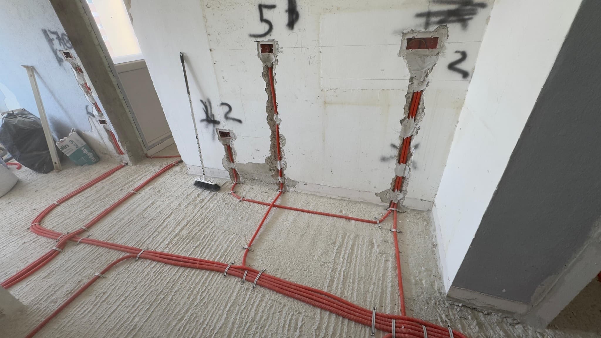 Wall chases with numbered outlets prepared for cable pulling.