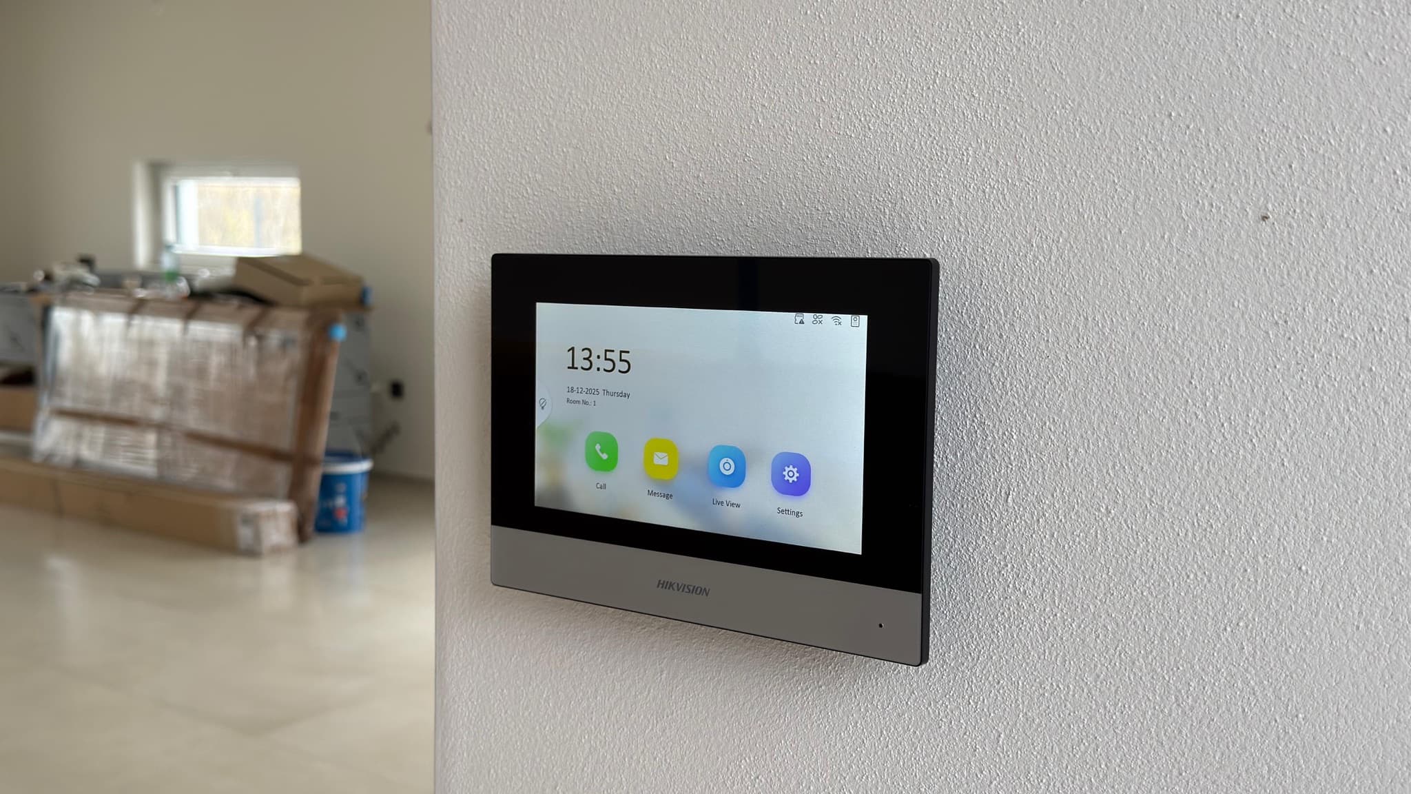 Wall-mounted touchscreen control panel in a modern interior.